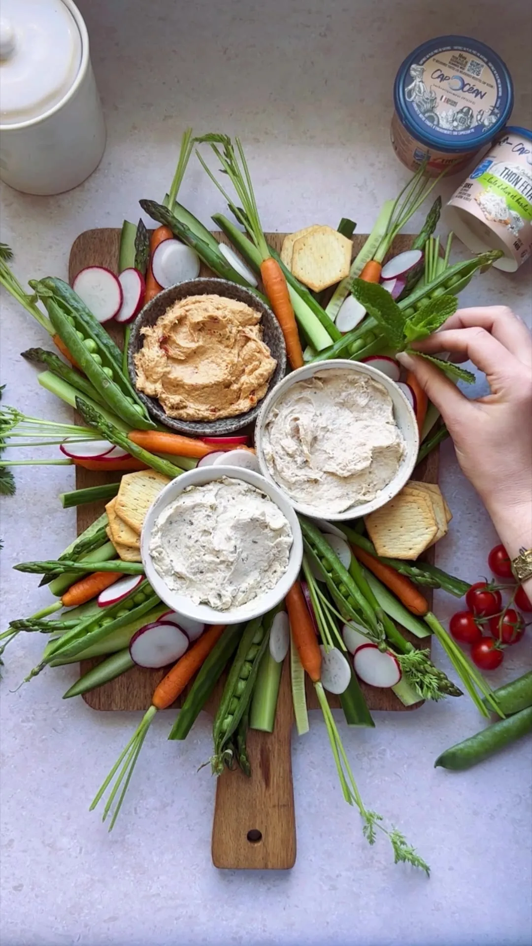Planche apéro de légumes croquants, houmous et sauces au fromage frais, dressée en extérieur