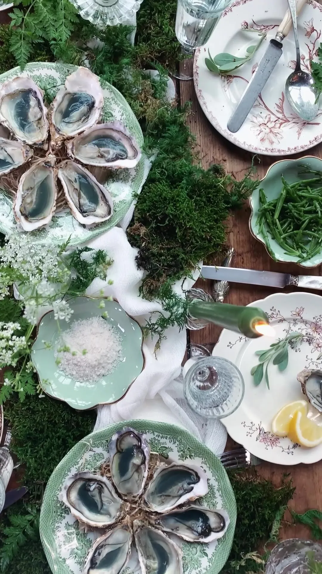 Table dressée vue du dessus : huîtres sur assiettes vertes, citrons et verres, au fil des saisons