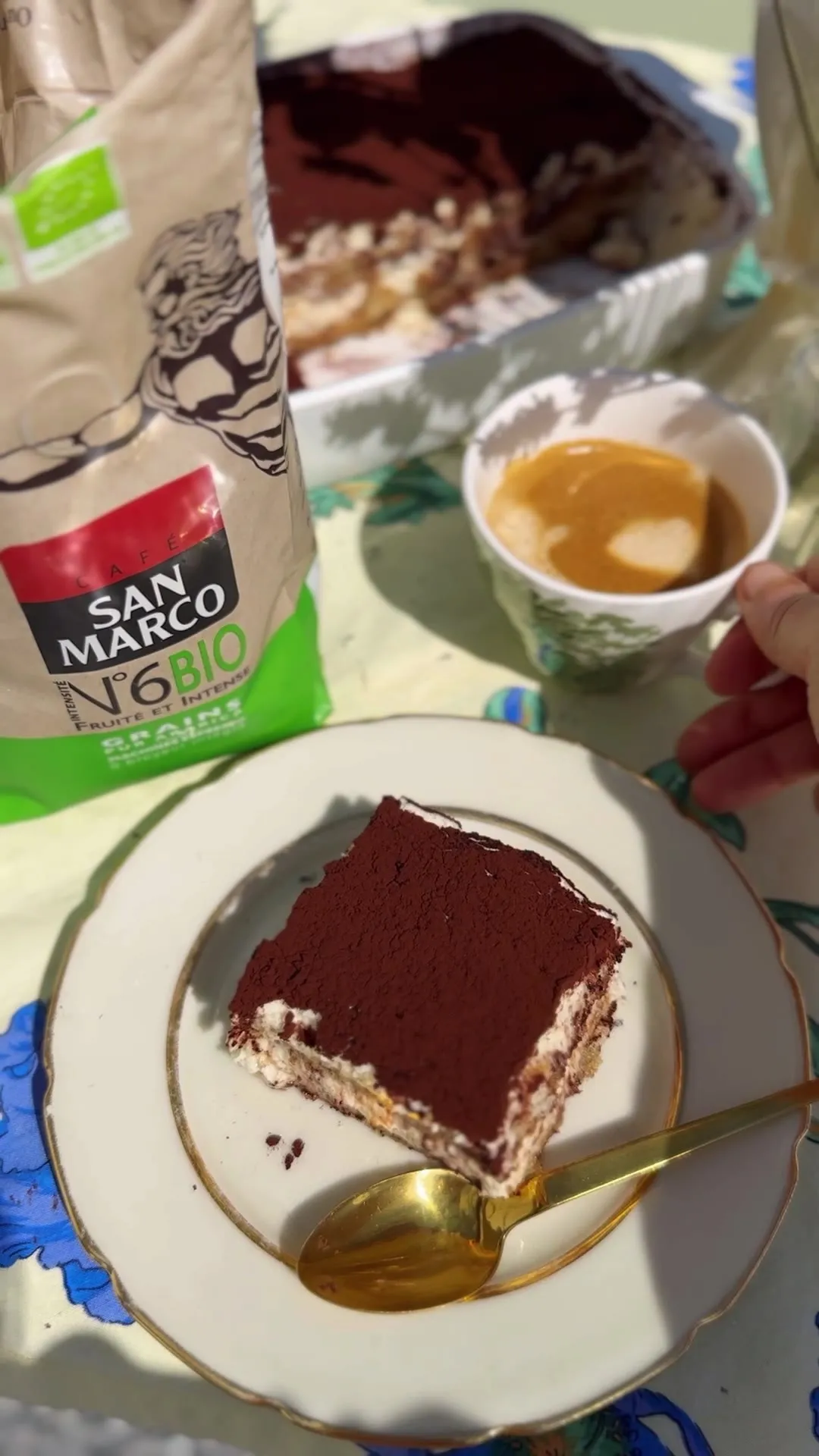 Tiramisu au café servi à la part, à côté d'une tasse d'expresso