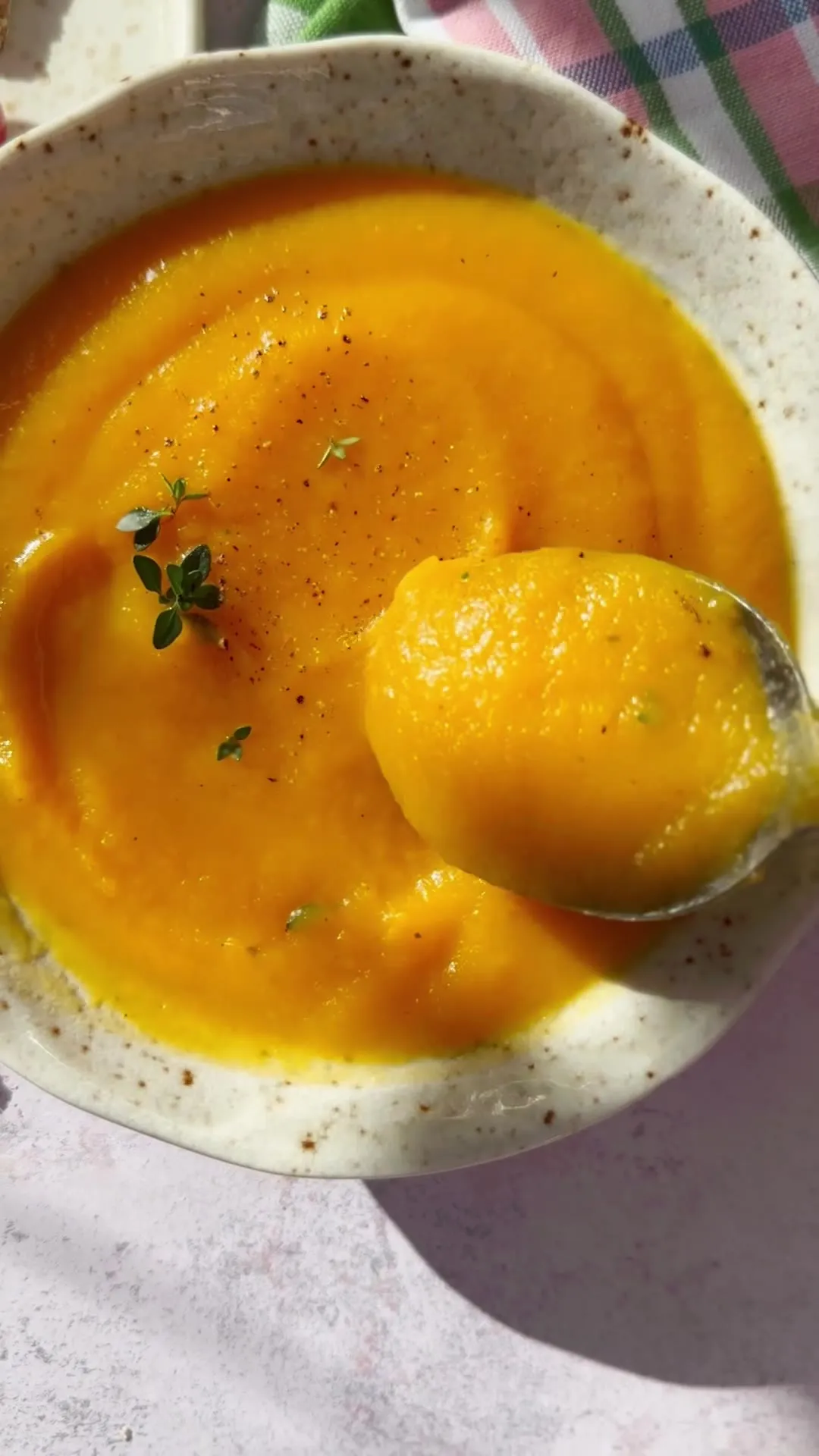 Velouté orangé servi avec du pain croustillant et des fruits rouges
